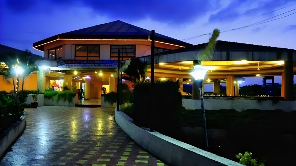 Illuminated luxury resort entrance with golden lights and landscaped pathway at Kapila Resorts Kharadi Pune at dusk
